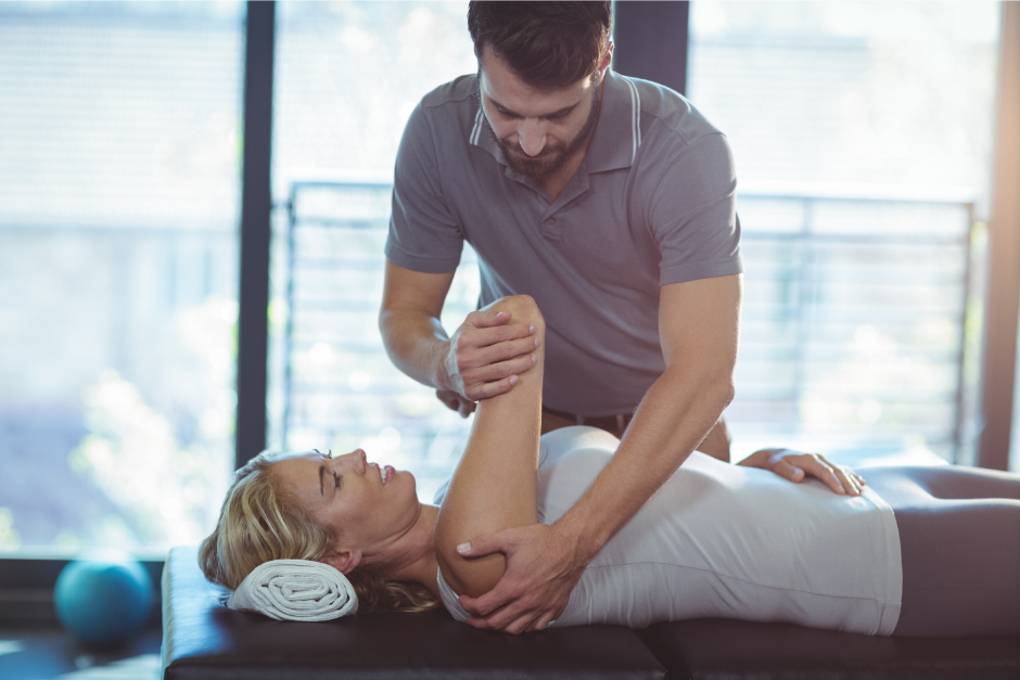 Physiotherapist giving shoulder therapy to a woman