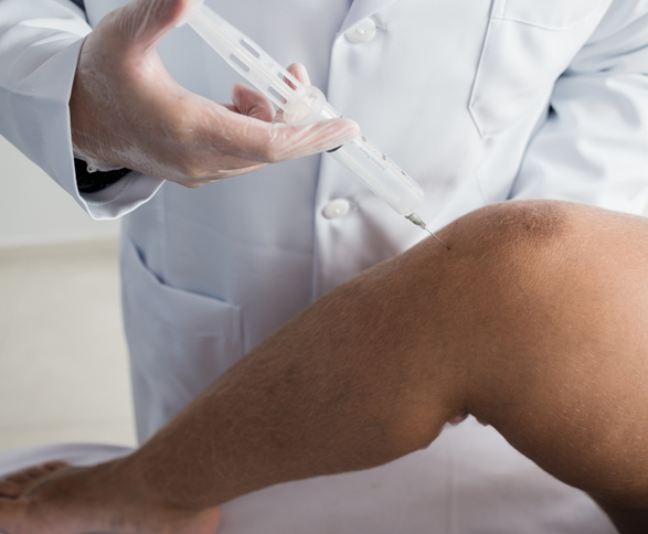 Medical professional inserting syringe into a patient’s knee