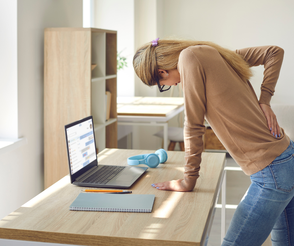 Employee with standing desk suffering from lower back pain